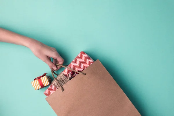 Mão segurando saco de papel com presentes — Fotografia de Stock