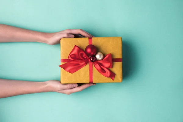 Hands holding christmas gift — Stock Photo
