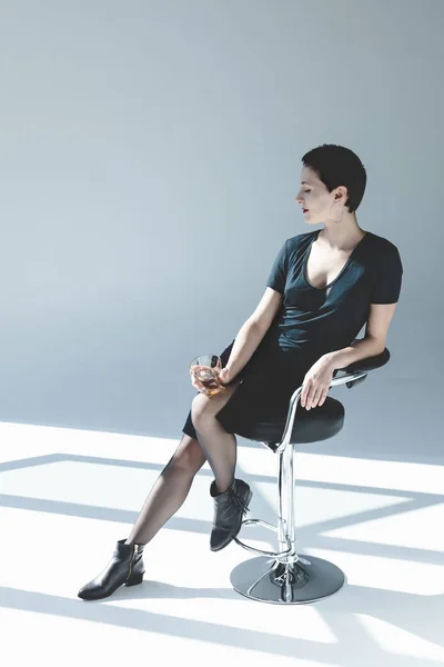Mujer joven bebiendo whisky - foto de stock