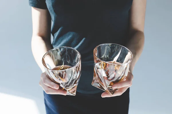 Person holding glasses with brandy — Stock Photo