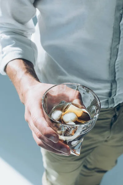 Man holding whiskey with ice — Stock Photo