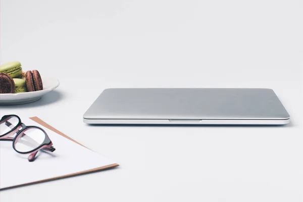 Posto di lavoro con computer portatile e macaron — Foto stock