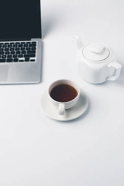 Tasse de thé et ordinateur portable — Photo de stock