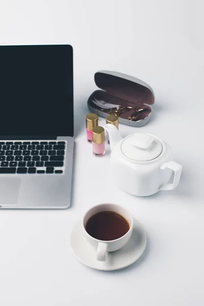 Lieu de travail girly avec ordinateur portable et thé — Photo de stock