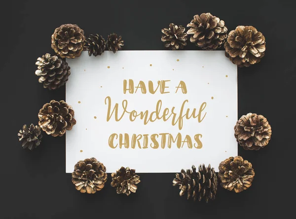 Pine cones and card with greeting — Stock Photo