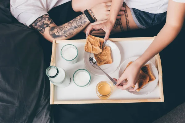 Pareja desayunando juntos en la cama - foto de stock