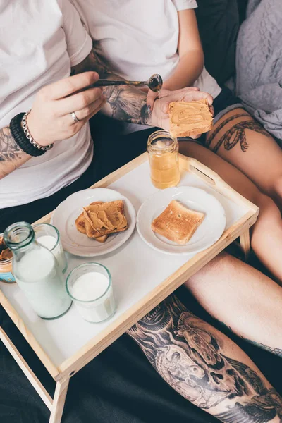 Pareja desayunando juntos en la cama - foto de stock