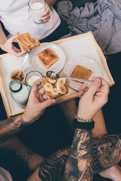 Couple manger des toasts au lit — Photo de stock