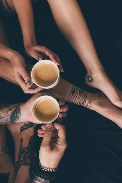 Pareja con tazas de café en la cama - foto de stock