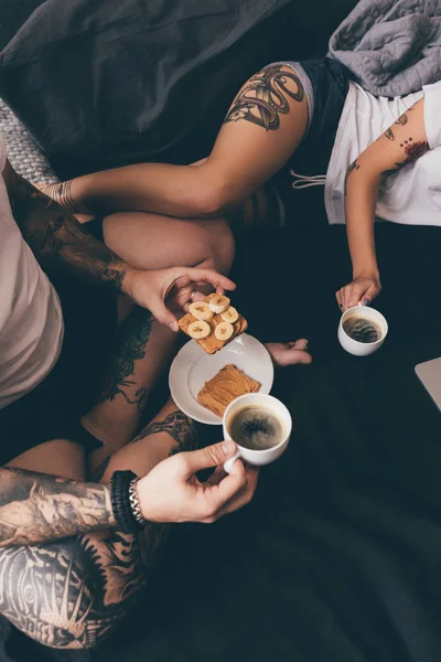 Pareja con tostadas y café en la cama - foto de stock