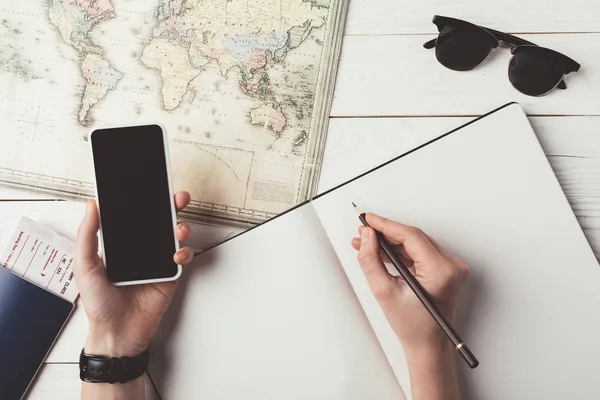 Hombre planificación de viajes con teléfono inteligente y mapa - foto de stock