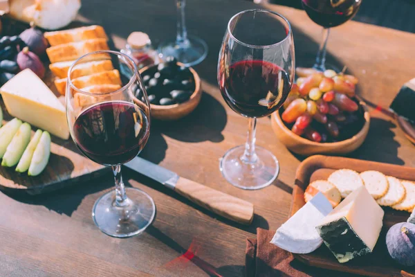 Красное вино с различными закусками — стоковое фото
