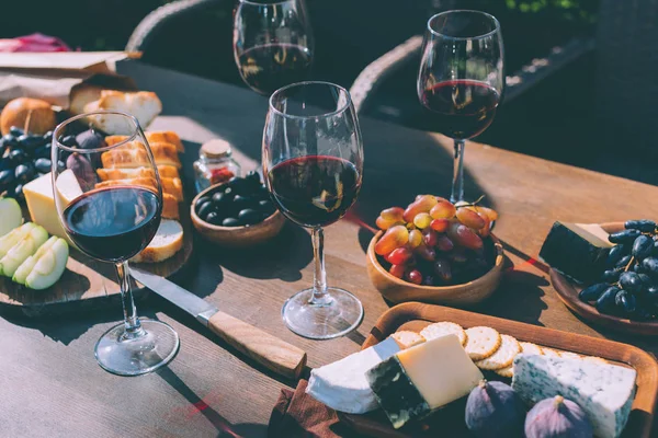 Vino tinto con varios aperitivos - foto de stock