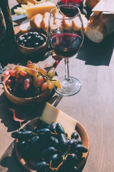 Vino tinto con varios aperitivos - foto de stock