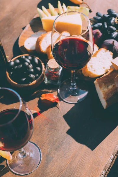 Red wine with various snacks — Stock Photo