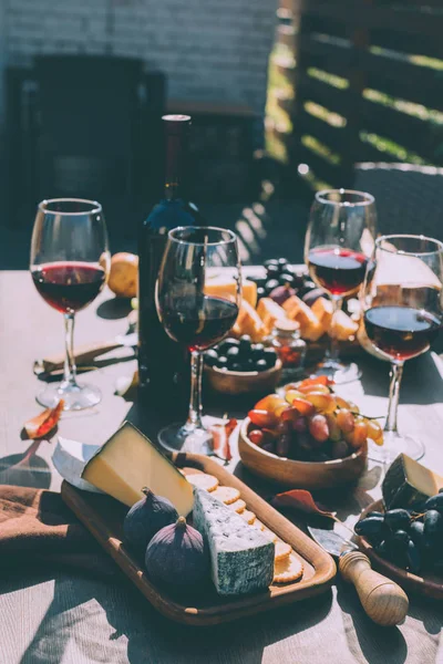Vin rouge avec diverses collations — Photo de stock