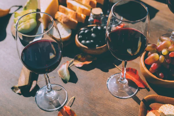 Red wine with various snacks — Stock Photo