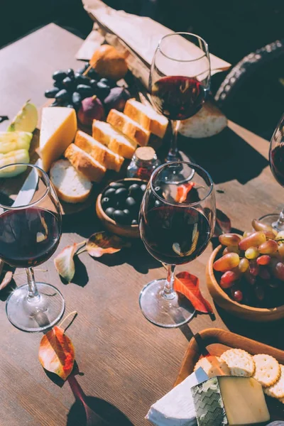 Red wine with various snacks — Stock Photo