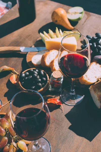 Vin rouge avec diverses collations — Photo de stock