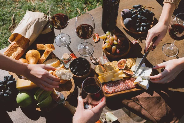 Personas bebiendo vino y comiendo al aire libre - foto de stock