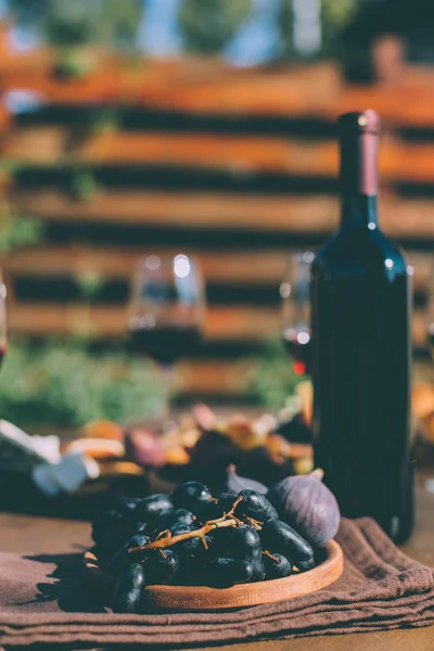 Vino tinto y frutas en el plato — Stock Photo