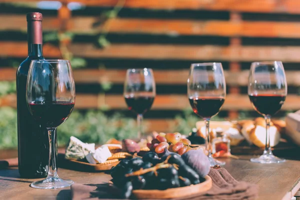 Red wine and various snacks — Stock Photo