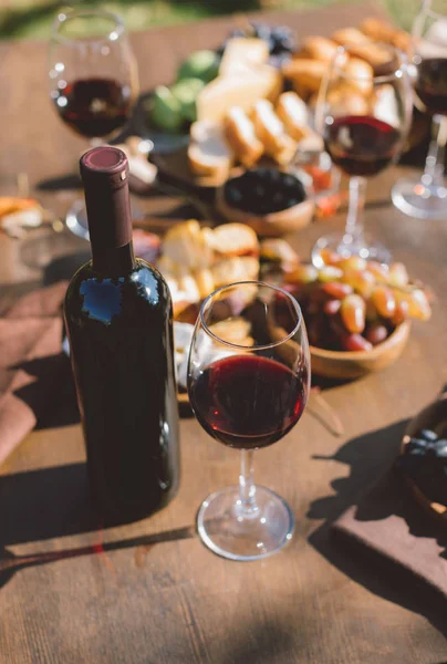 Red wine and various snacks — Stock Photo