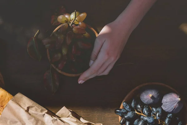 Woman holding bowl of grapes — Stock Photo