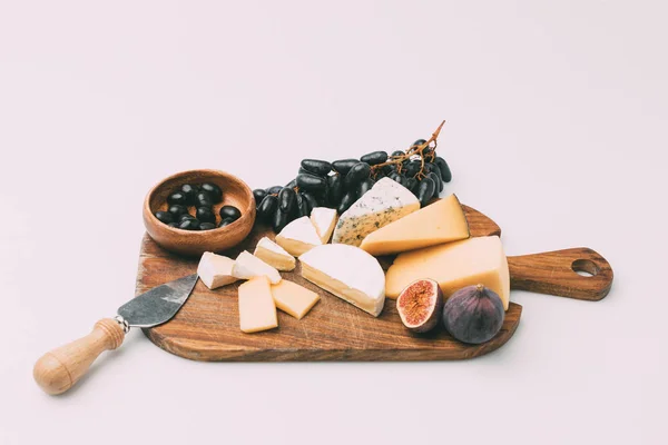 Snacks for wine on wooden cutting board — Stock Photo