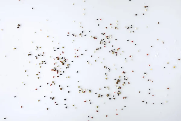 Scattered pepper on white surface — Stock Photo