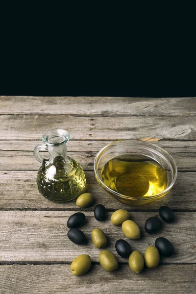 Botella de vidrio y tazón con aceite de oliva - foto de stock