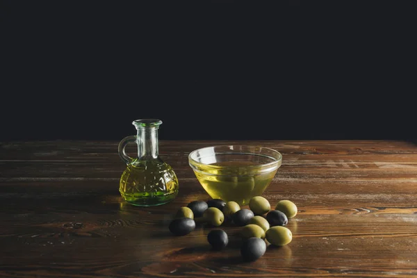 Botella de vidrio y tazón con aceite de oliva - foto de stock