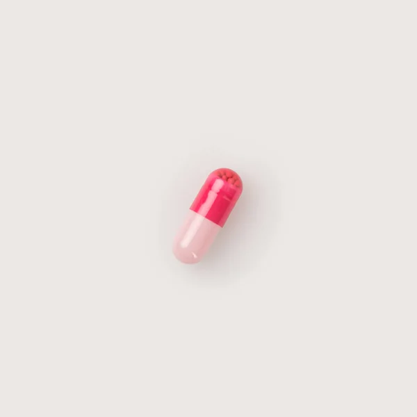 One red and pink pill — Stock Photo