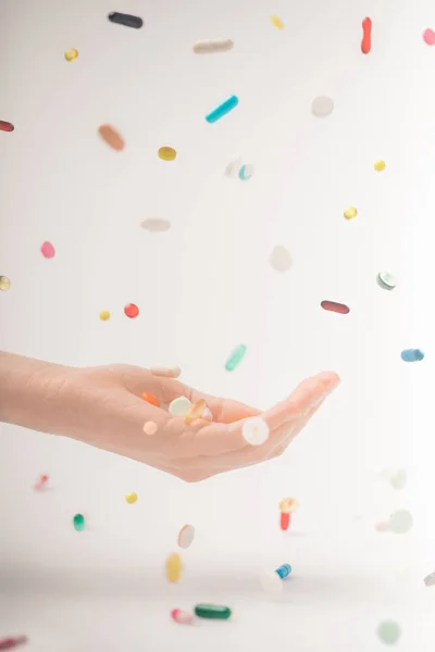 Weibliche Hand fängt fallende Pillen — Stockfoto