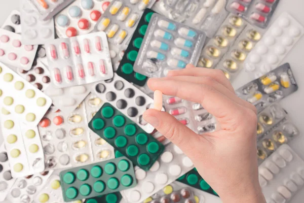 Woman holding pill in hand — Stock Photo