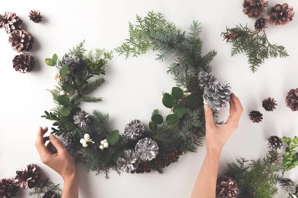 Manos haciendo corona de Navidad - foto de stock