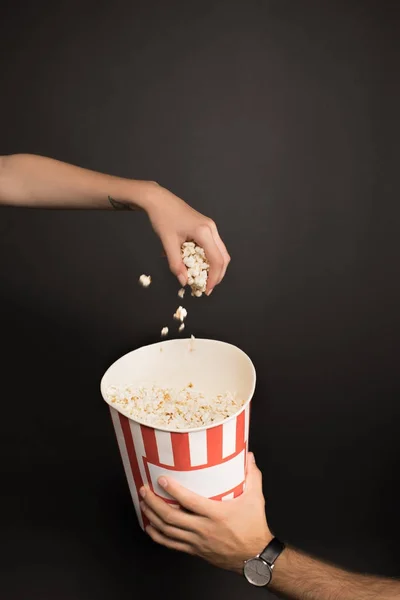 Woman taking popcorn out of bucket — Stock Photo