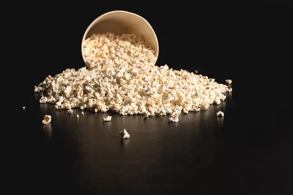 Popcorn spilled from cardboard bucket — Stock Photo