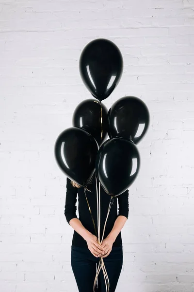 Woman holding black balloons — Stock Photo