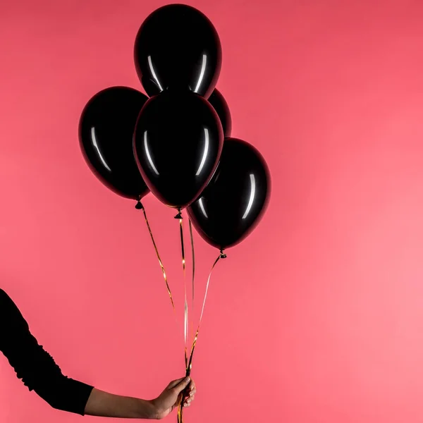 Woman holding black balloons — Stock Photo