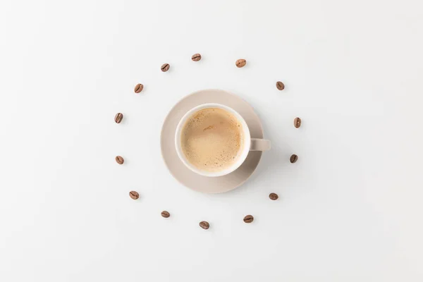 Coffee cup surrounded with beans — Stock Photo