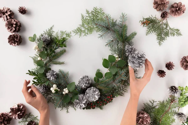 Manos haciendo corona de Navidad - foto de stock