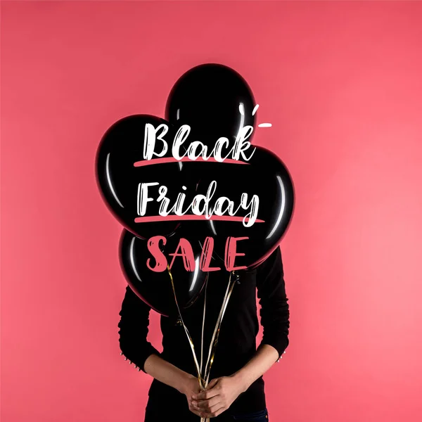 Woman holding black balloons — Stock Photo