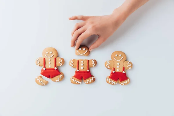 Hand with crashed gingerbread men — Stock Photo