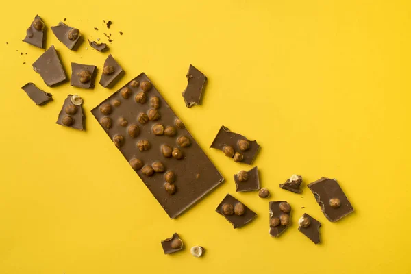 Barra di cioccolato con pezzi sparsi — Foto stock