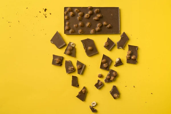 Barra de chocolate com peças espalhadas — Fotografia de Stock