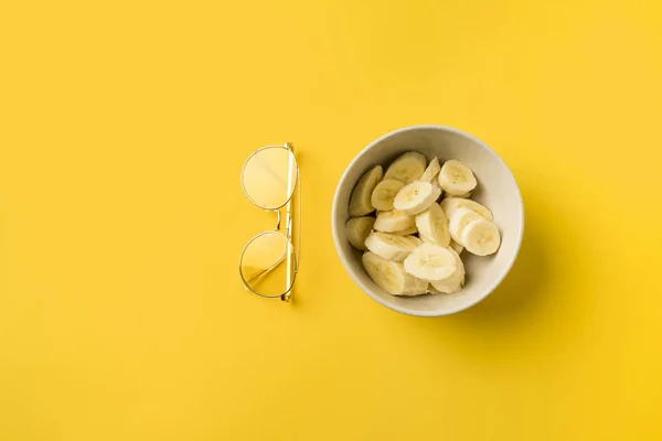 Assiette avec bananes coupées et verres — Photo de stock