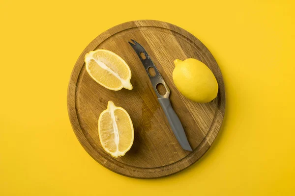 Lemons and knife on wooden board — Stock Photo