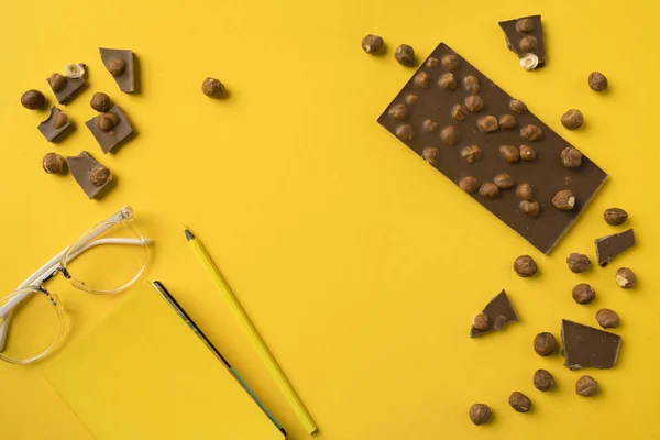 Notebook with pencil and chocolate — Stock Photo