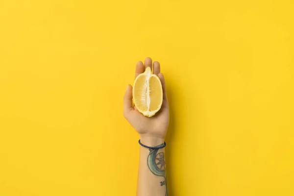 Woman holding half of lemon — Stock Photo